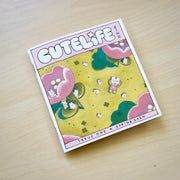 "Cutelife" zine cover, featuring an illustration of a small girl laying in an open green field, seen from overhead. Many small bunnies are around her and large pink flowers.