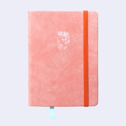 Peach colored pleather covered sketchbook with a small embossment of a robot carrying a flag that reads "Giant Robot" in the upper center. A bright orange elastic band keeps the sketchbook closed.