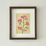 Painting of a pink flower, with 5 blossoms and a thin green stem. Around it fly small fairies with long braids and green moth wings. Piece in its frame.