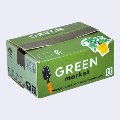 Small cardboard box made to look like a shipping package of garden supplies, with stickers on top of green themed items and garden gear.