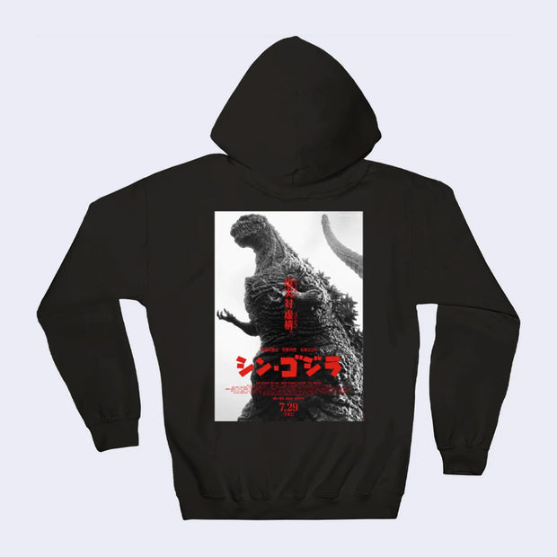 Back view of black pull over hoodie, with a black and white photograph of Godzilla with red Japanese kanji text on top of it.