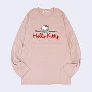 Dusky pink long sleeve shirt with a graphic in the center of Hello Kitty reading a book. Around her says "Hmmmmm.." with half the text on one side and the other half on the other. Below is a red yarn embroidered element spelling out "Hello Kitty".