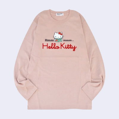 Dusky pink long sleeve shirt with a graphic in the center of Hello Kitty reading a book. Around her says "Hmmmmm.." with half the text on one side and the other half on the other. Below is a red yarn embroidered element spelling out "Hello Kitty".