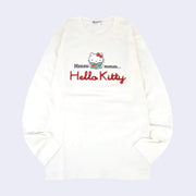 White long sleeve shirt with a graphic in the center of Hello Kitty reading a book. Around her says "Hmmmmm.." with half the text on one side and the other half on the other. Below is a red yarn embroidered element spelling out "Hello Kitty".