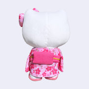 Plush doll of Hello Kitty, dressed in a pink kimono with cherry blossom pattern. She has a matching hair bow and sandals. Back view.