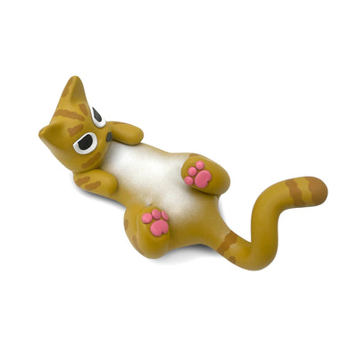 Small clay sculpture of a light brown cat laying on its back, with its feet up to show pink toe pads. It has a slightly worried expression.