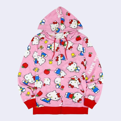 Pink hooded zip up jacket with a repeating all over pattern of Hello Kitty, standing and sitting with flowers and apples. "Hello Kitty" is written in white font throughout the pattern.