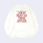 Back view of a white sweatshirt with text in all caps reading "I am as heavy as three apples!" with a small line art graphic of Hello Kitty's head appearing along the top of the text block.