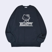 Navy blue sweatshirt with a white ink line art graphic of Hello Kitty, sitting and holding an apple in her hand. Below her is fully capitalized text that reads "Hello Kitty" in white font.