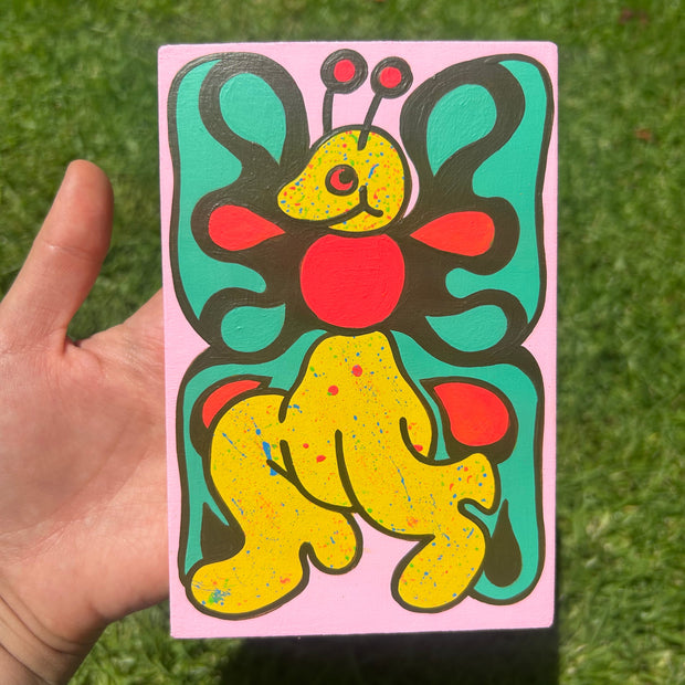 A cartoony-cute butterfly with boots on. The artist used a paint splatter technique that's only over where the body and head is.