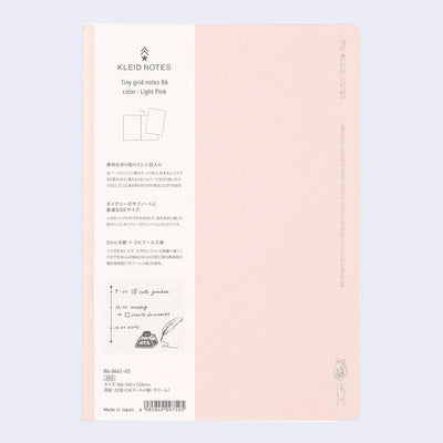 Light pink notebook cover with subtle silver embossed designs and words along the sides.