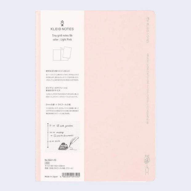 Light pink notebook cover with subtle silver embossed designs and words along the sides.