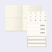 Interior of a notebook with lined ivory colored paper and a small sticker set of numbers and "idea" spaces.