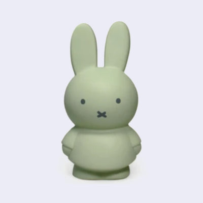 Miffy shaped coin bank, completely colored a grayish shade of green with gray eyes and mouth. She stands wearing a dress with her arms at her sides.