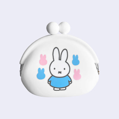 White silicone coin pouch with Miffy wearing a blue dress and standing in the middle. Around her are pink and blue silhouetted Miffy heads, 2 of each color.