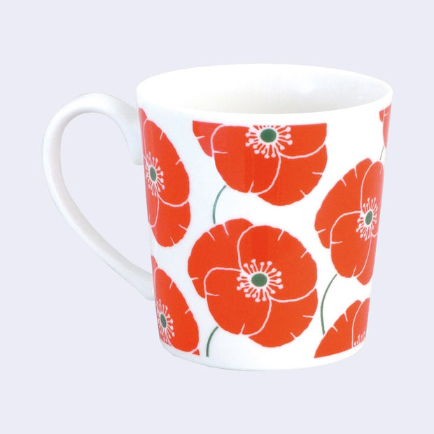 White ceramic mug featuring an orange flower pattern all over the mug.