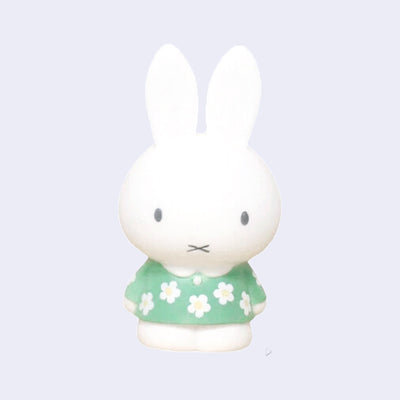 Figure of Miffy standing with her arms at her side and wearing a light mint green dress with floral patterning.