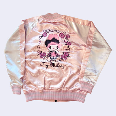 Shiny polyester bomber style jacket with a light pink body and off white sleeves. The back has a large embroidery of My Melody, dressed in a fluffy pink dress and surrounded by white decorated lines and pink roses.