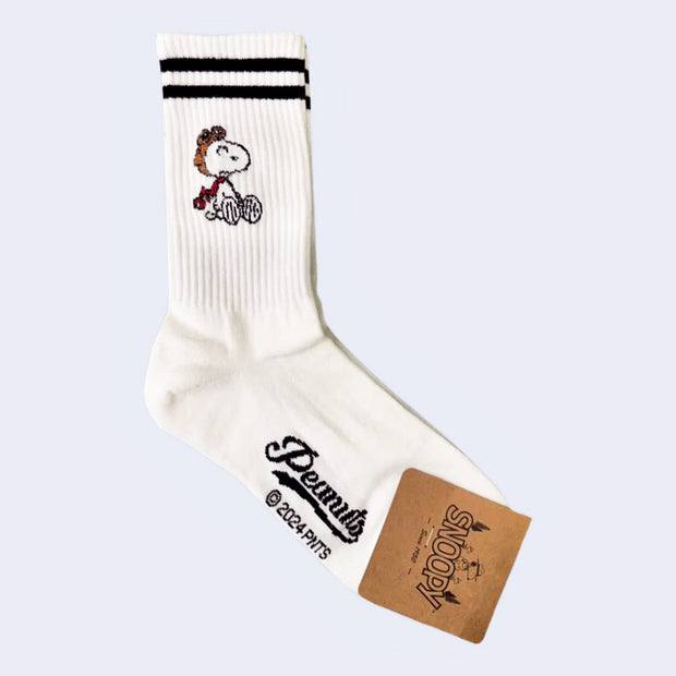 White crew, mid calf socks with 2 black stripes along the top. They have illustrations of Snoopy, sitting on the ground with a confused expression and dressed like the Flying Ace.