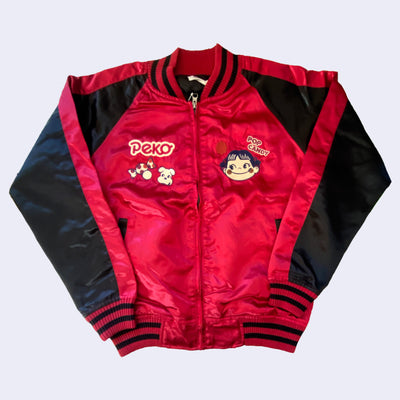 Shiny red bomber jacket with black sleeves and small embroideries on the chest of Peko Chan, a smiling girl with rosy cheeks and candy accessories.