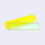 Yellow translucent pencil case with a mint green colored bottom, open so the lid is slightly off the base. 