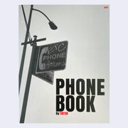 Front cover for "Phone Book" featuring a greyscale photo of a graffiti'd sign for a public telephone.