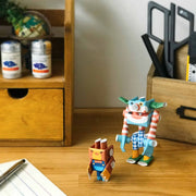 Pair of 2 robots made out of paper pipes, bent to built the robots. One is tall and resembles a clown and the other is short and resembles an angry bear.