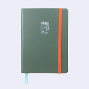 Granite green colored pleather covered sketchbook with a small embossment of a robot carrying a flag that reads "Giant Robot" in the upper center. A bright orange elastic band keeps the sketchbook closed.