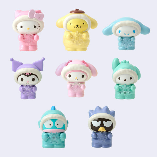 8 different Sanrio characters, all wearing fluffy snowsuits with a fur lined hood pulled on and holding a clear snowflake in their hands. Characters are: Hello Kitty, Pompompurin, Cinnamoroll, Kuromi, My Melody, Pocchaco, Hangyodon and Tuxedo Sam.