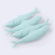 4 pale blue erasers shaped like sardines.