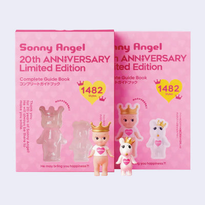 Pink book half removed from its plastic sleeve with 2 small Sonny Angel figures.