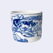 White porcelain mug with a dark blue line art illustration wrapped around it. A large koi fish with the number "14" on its side swims over a curling ocean wave.