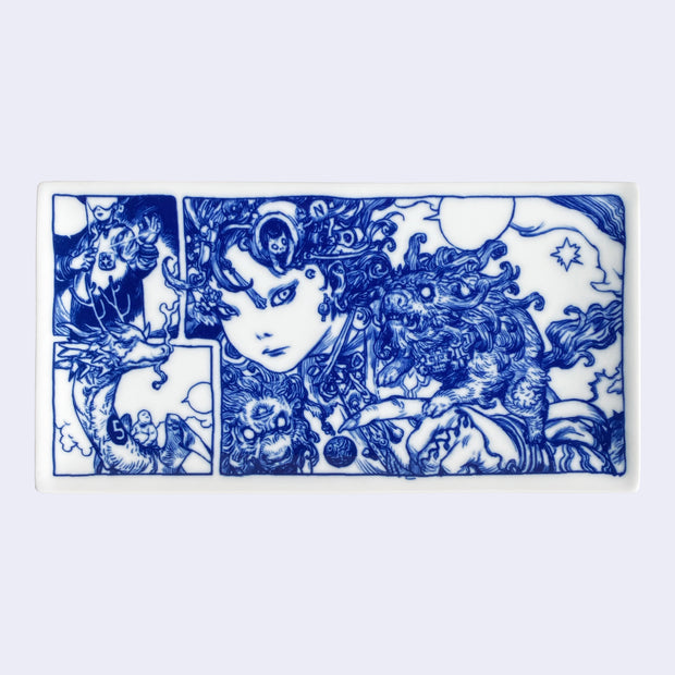 Rectangular shaped white porcelain plate with dark blue line art illustrations, depicting a woman with miniature lion like creatures on her shoulder and under her face. She looks at the viewer with a serious expression. To the left are illustrated panels of a person riding a dragon and another person creating a laser with their fingers.