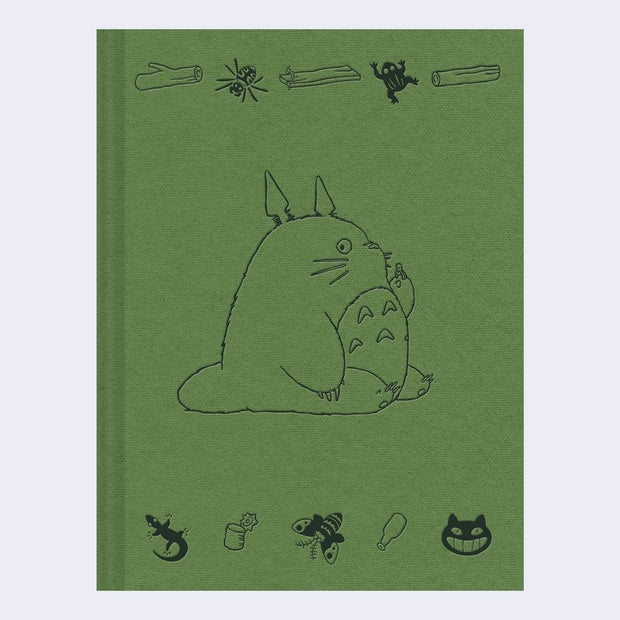 Green fabric hardcover journal with embossed illustrations of Totoro, sitting and faced to the side. Along the top and bottom are smaller nature themed doodles.