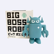 Sculpted dusty blue colored Big Boss Robot, standing with its arms at its side. Behind is a product packaging box that reads "Big Boss Robot" in bold all caps font, with Japanese script below. An illustrated Big Boss Robot is in upper right corner. 