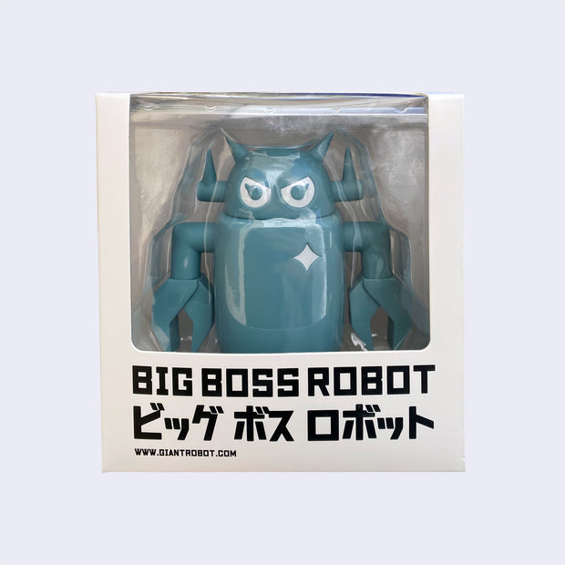 Sculpted dusty blue colored Big Boss Robot, encased in a display packaging box, with the top 3/4ths of the robot viewable and the rest blocked by packaging that reads "Big Boss Robot" in bold black font with Japanese script underneath.