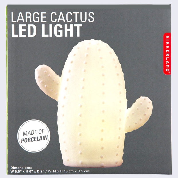 White ceramic lamp in the shape of a cactus with a short and stout body and 2 limbs growing off it. Surface has small dots.