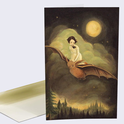 The front of note card is shown. The notecard has an illustration of a girl who rides on a brown bat over a the tree tops of a dark forest.