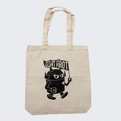 Cream colored canvas tote bag with drop handle. On the front is a design of Big Boss Robot walking and holding a pennant shaped flag that says "Giant Robot," some of the letters obscured as a flag ripple effect.