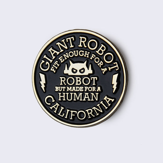 Black and gold circular enamel pin that reads "Giant Robot" on top, "fit enough for a robot but made for a human" in the middle and "California" on the bottom. A small robot logo is in the middle and a lightning bolt on the left and right side.