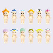 12 vinyl Kewpie babies, standing nude with different marine themed creatures atop their heads like hood hats. Options are: starfish, whale, dolphin, clownfish, penguin, seahorse, jellyfish, blowfish, shell, otter, manta and shark.