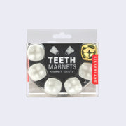 Product packaging for a 6 tooth shaped magnets, one of them is gold and the other are all white.