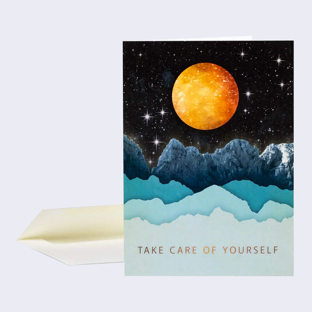 Greeting card with a full bleed illustration of a dark starry sky over some icy mountains, some realistic and some made from simplistic paper cuts. A bright orange moon hangs in the sky and "Take care of yourself" is written at the bottom.