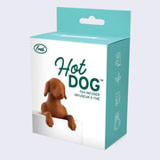 Product packaging of a white box with teal sides, a photo of a rubber brown dachshund halfway submerged in a white ceramic mug on the cover with "Hot Dog Tea Infuser" written on the box. 