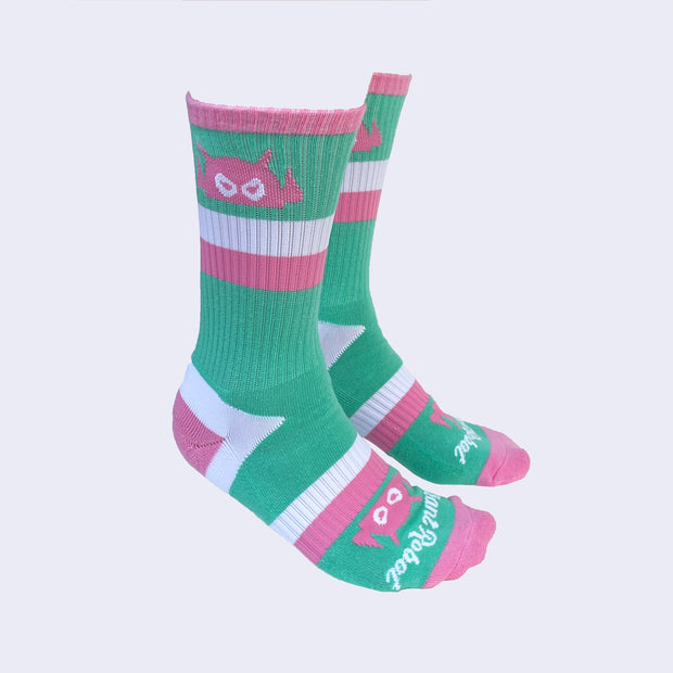 A side view of model's feet wearing striped socks. The angry robot decorates the cuff of each sock so that it peeks out when you wear sneakers.