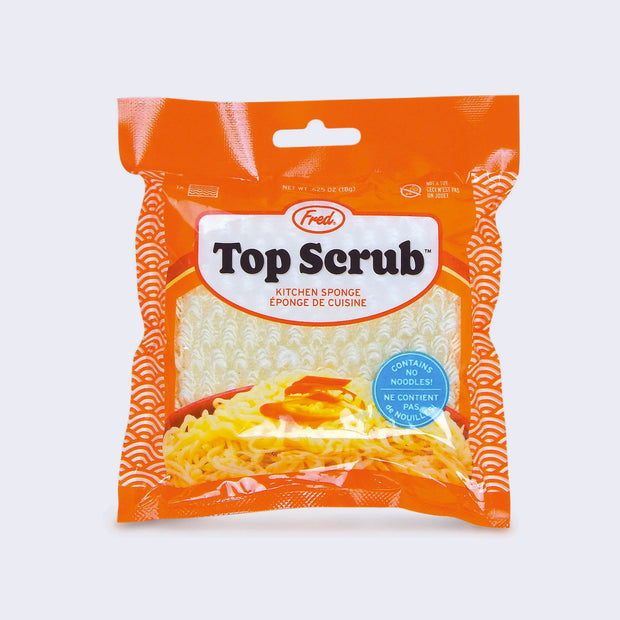 Orange product packaging made to look like a Top Ramen packet, with a sponge visible inside that resembles a block of uncooked ramen noodles. Text says "Top Scrub"